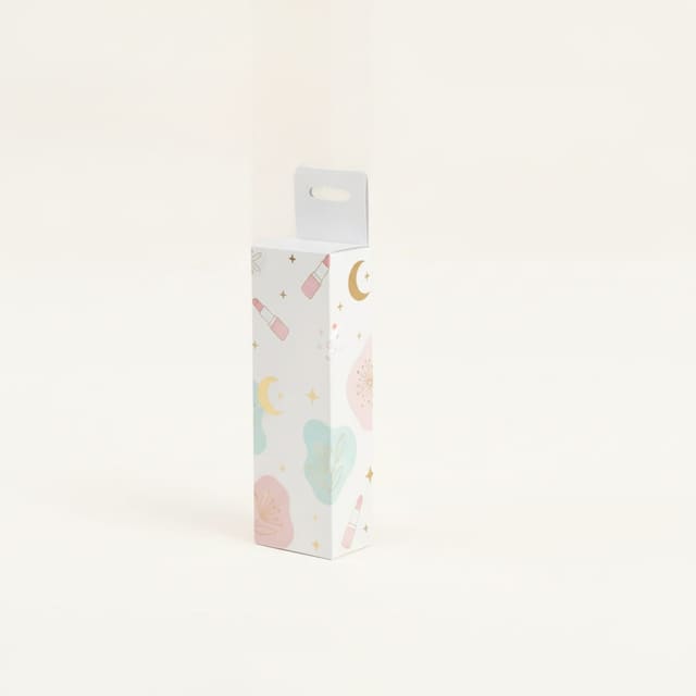 Caja alargada blanca decorada con dibujos en tonos pastel y detalles dorados
